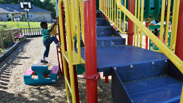 A child plays near a housing unit at Our House, a nonprofit that provides child care, shelter, and other programs for working homeless people in Little Rock, Arkansas, on October 10, 2013. (AP/Danny Johnston)