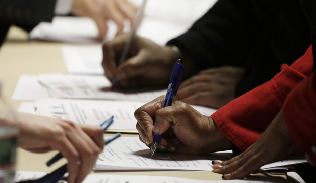 Job applicants complete forms at a job fair sponsored by Swissport in Newark, New Jersey, Wednesday, February 6, 2013. (AP/Mark Lennihan)