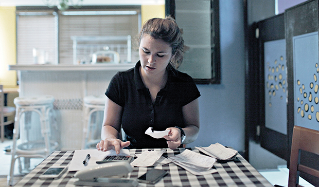 Kristeen Rogers, 23, of Clermont, Florida, a single mother of two girls, Lexi, 4, and Jada, 2, works multiple jobs to pay the bills, put food on the table, and get her girls into daycare. At the end of her shift waitressing at The Mad Melon Cafe Rogers, she sits down to cash out, turn in her checks, and collect her tips. She made about $75 in tips, money that was soon spent on gas and groceries. (Melissa Lyttle)