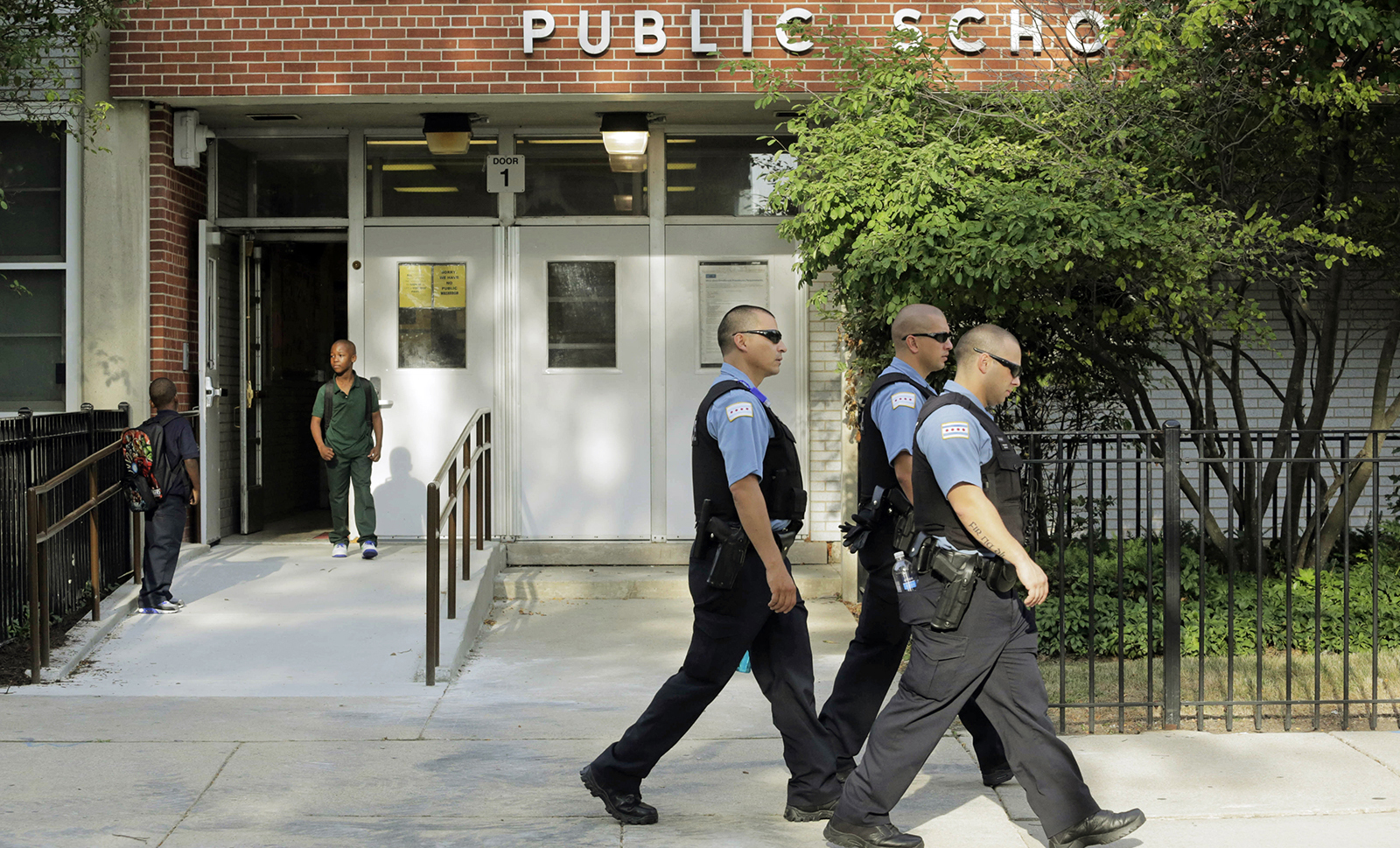 Chicago Police patrol the neighborhood as children arrive at Gresham Elementary School on the first day of classes, Monday, August 26, 2013, in Chicago. (AP/M. Spencer Green)