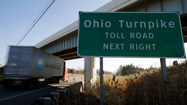 This Wednesday, December 12, 2012 photo shows a truck driving past a sign for the Ohio Turnpike near Streetsboro, Ohio. (AP/Tony Dejak)