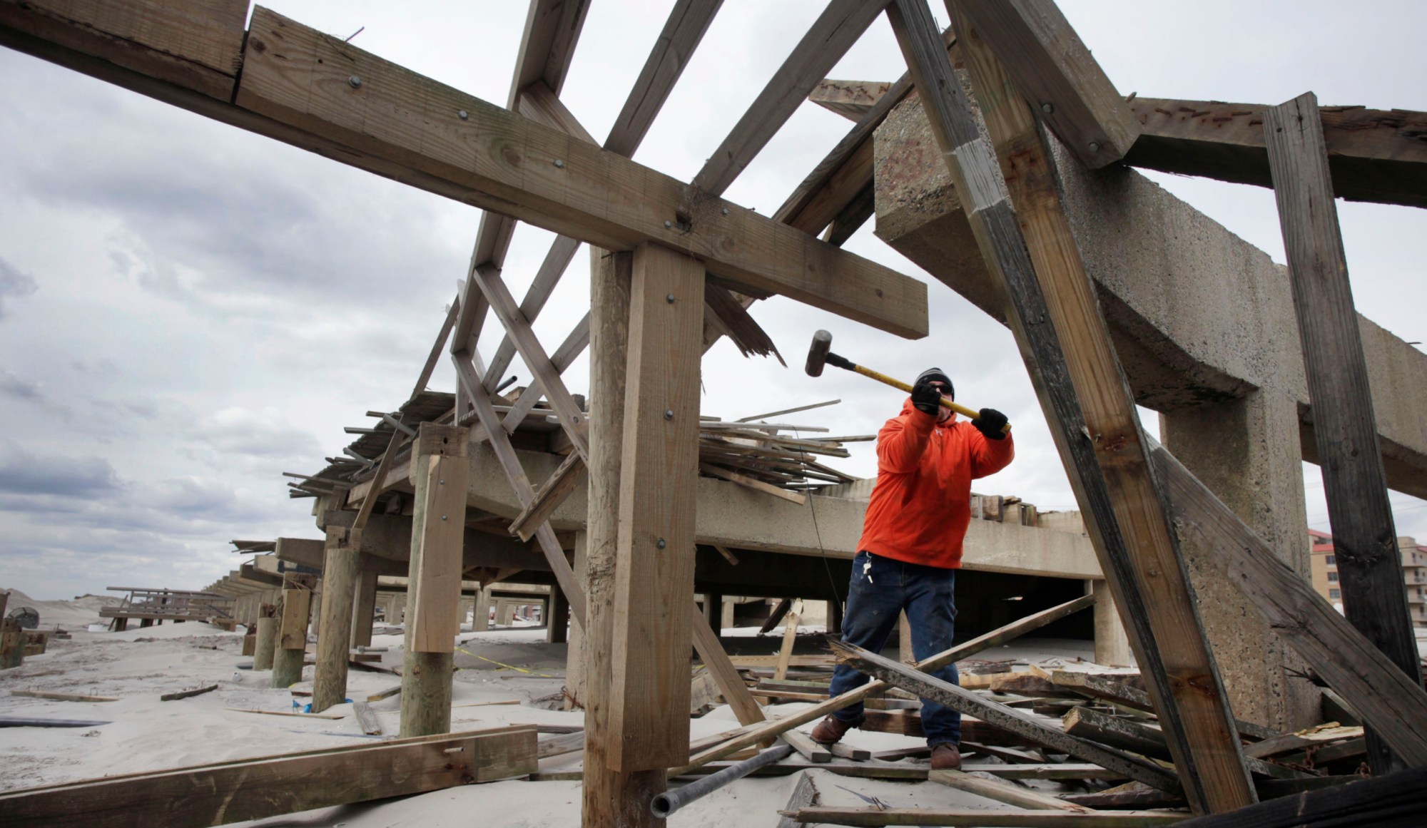 Shawn Polito uses a sledgehammer to knock apart timbers on the Long Beach, New York boardwalk, which was devastated by Superstorm Sandy. (AP/Mark Lennihan)