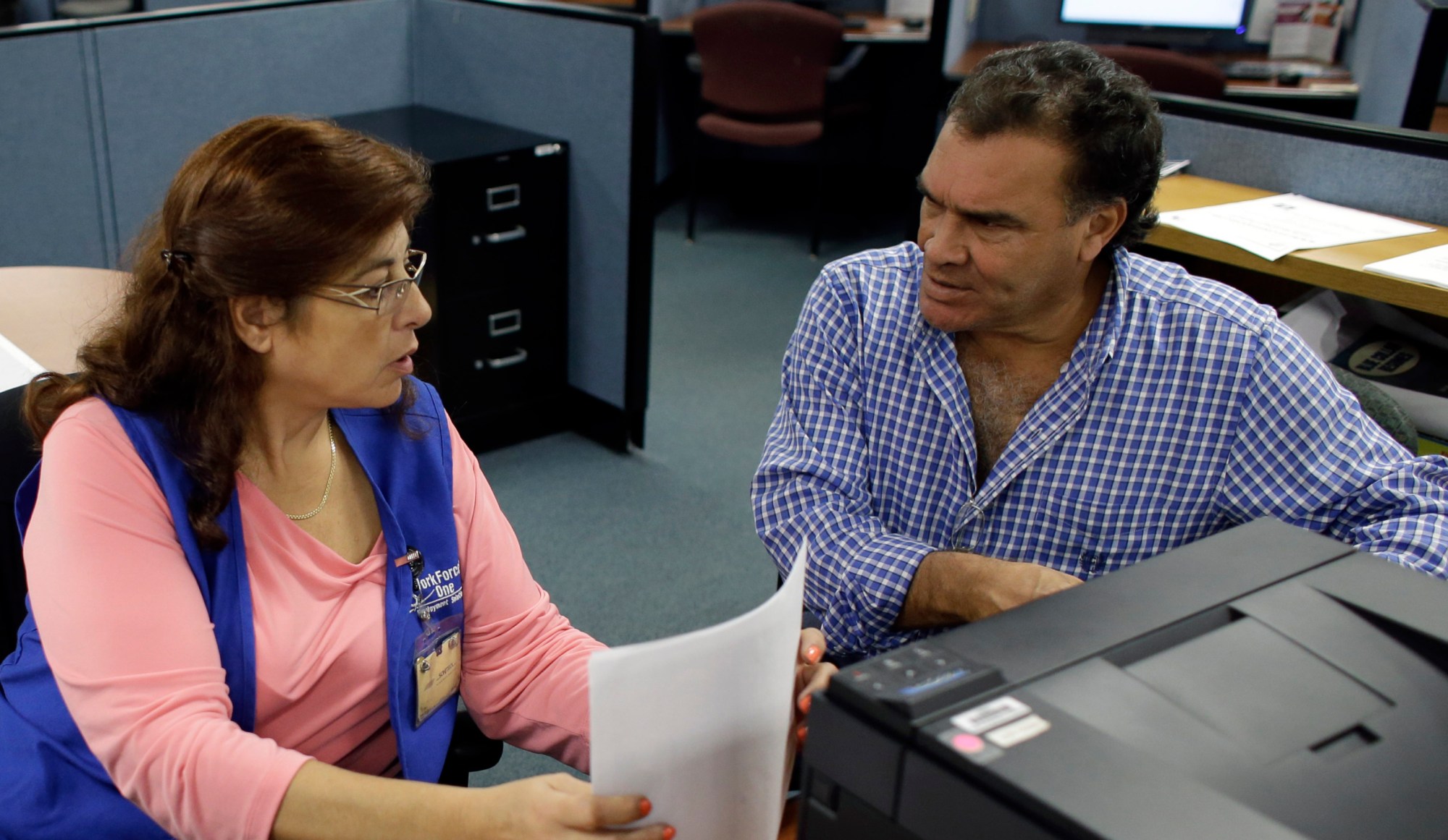 Rose Capote-Marcus, left, helps Waldemar Vega with problems he is having receiving his unemployment benefits at WorkForce One in Davie, Florida. (AP/Lynne Sladky)