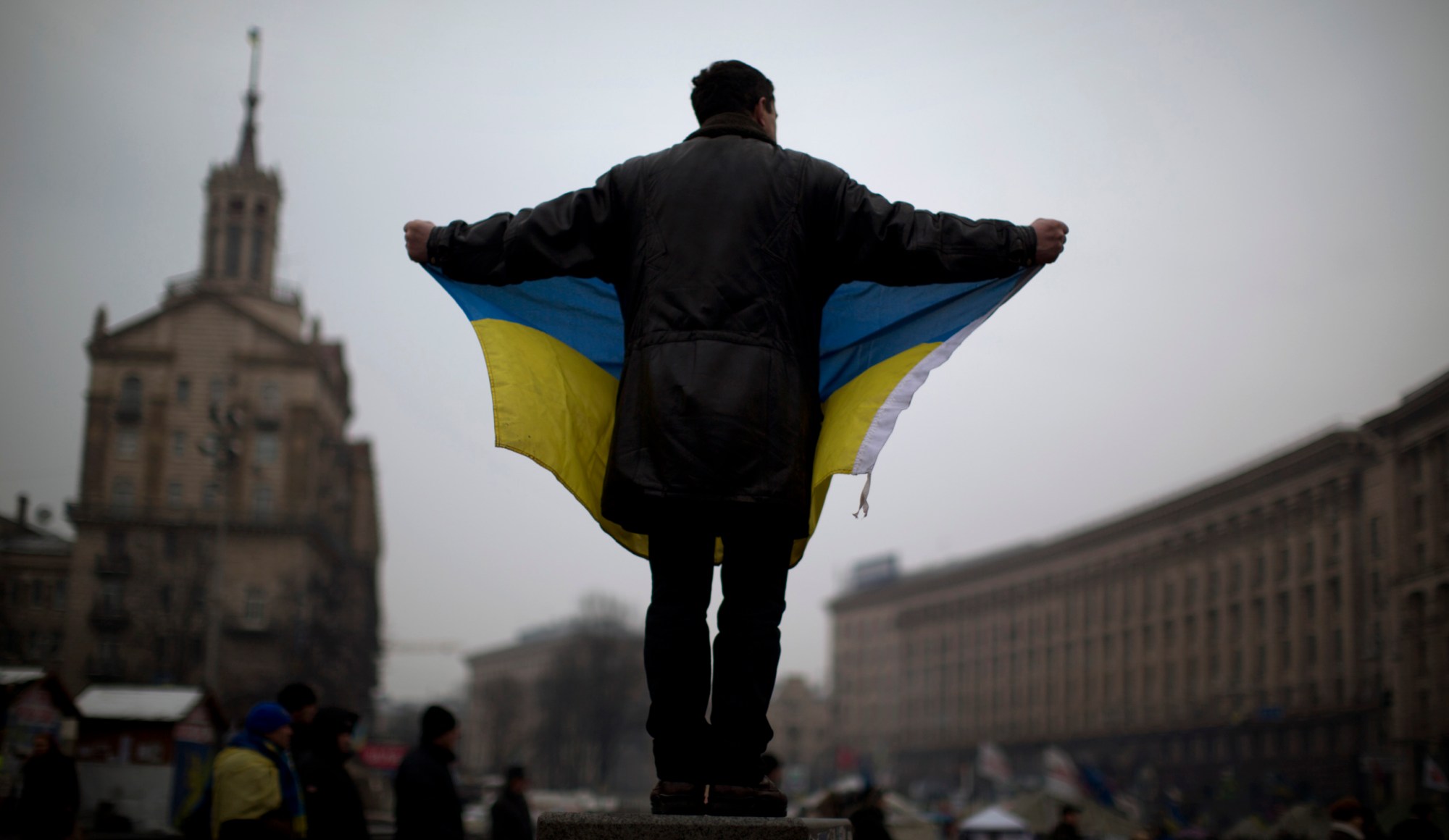 An opposition supporter holds a Ukrainian flag in the center of Kiev's Independence Square. (AP/Emilio Morenatti)