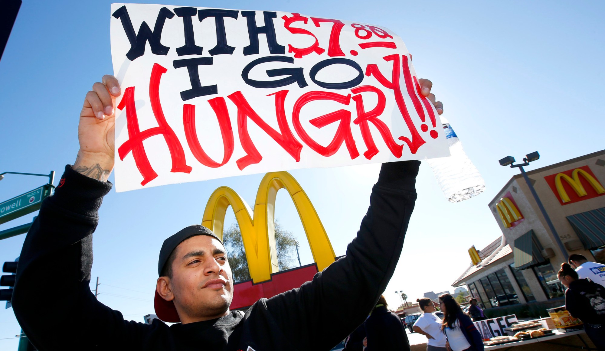 Alex Robles joins dozens of sign-holding protesters at a rally against low wages in front of a McDonald's in December 2013. (AP/Ross D. Franklin)