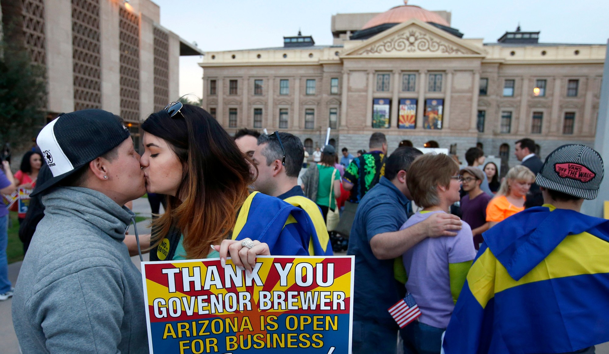 With the Arizona State Capitol in the background, LGBT rights supporters  Jo Jo Halko and Rachel Butas kiss after learning that Gov. Jan Brewer vetoed an anti-gay bill. (AP/Ross D. Franklin)