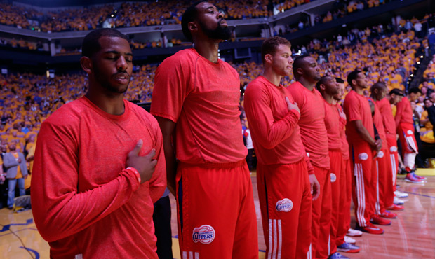 Los Angeles Clippers players listen to the national anthem wearing their warmup jerseys inside out to protest alleged racial remarks by team owner Donald Sterling before Game 4 of an opening-round NBA basketball playoff series against the Golden State Warriors on Sunday, April 27, 2014, in Oakland, California. (AP/Marcio Jose Sanchez)