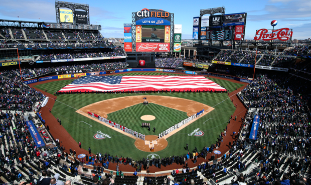 A giant American flag is unfurled before a baseball game between the New York Mets and Washington Nationals on Opening Day at Citi Field, Monday, March 31, 2014, in New York. (AP/John Minchillo)