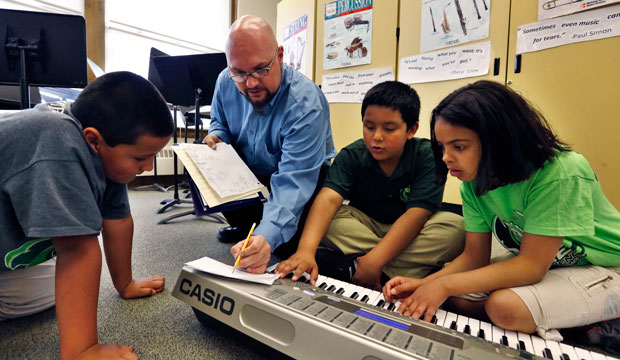 Conrad Kehn helps students compose during music class at Cole Elementary in Denver, Colorado. (AP/Brennan Linsley)