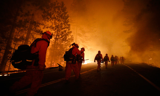 Firefighters walk along Highway 120 after a burnout operation as they continue to battle the Rim Fire near Yosemite National Park, California. (AP/Jae C. Hong)