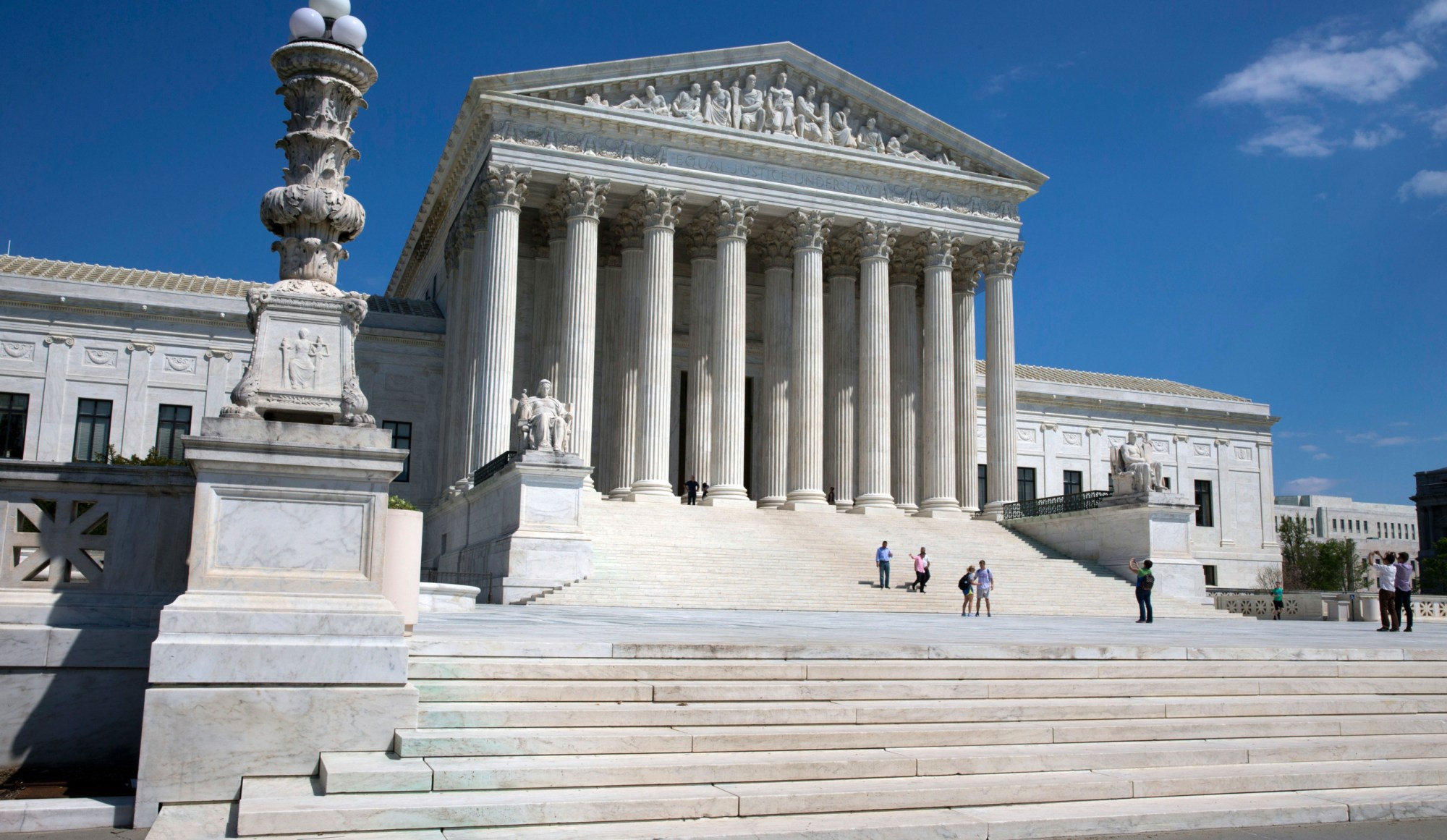 People walk on the steps of the U.S. Supreme Court in Washington, D.C. (AP Photo/Jacquelyn Martin)