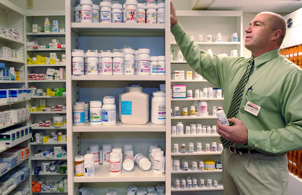 Pharmacist Salvatore Ciolino, Jr. reaches for a prescription bottle at a Gloucester, Massachusetts. (AP/Lisa Poole)