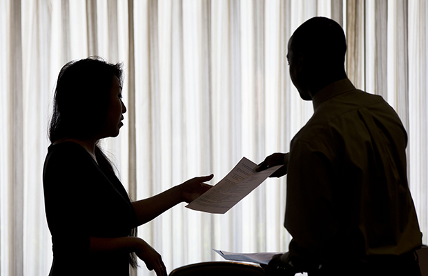 Recruiter Christina O, with New Western Acquisitions, left, take Raheem Shaw's resume during a job fair, June 23, 2014. (AP/Matt Rourke)