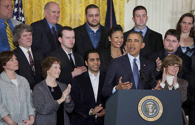 President Barack Obama, surrounded by workers and supportive business leaders, speaks during a signing ceremony in the East Room of the White House in Washington, Thursday, March 13, 2014, for a presidential memorandum directing Secretary of Labor Thomas E. Perez to modernize overtime protections. (AP/Manuel Balce Ceneta)