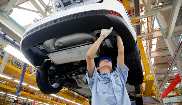 A worker assembles a vehicle on an assembly line at Ford factory in Chongqing, China. (AP)
