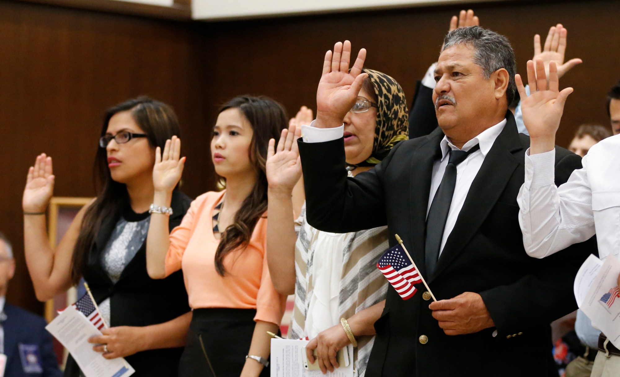 Eduardo Simenta of Mexico, raises his hand as he recites the Oath of Allegiance at a Naturalization Ceremony in Oklahoma City. (AP/Sue Ogrocki)