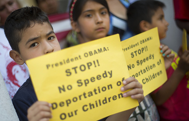 From left, Raul Amador Sanchez, 7, from Georgia, Alexandra Diaz, 9, and her brother Andy Diaz, 7, both from Baltimore, Maryland, hold up signs as they join their parents during a news conference of immigrant families and children’s advocates responding to President Barack Obama’s response to the crisis of unaccompanied children and families, Monday, July 7, 2014, on the steps of St. John's Church in Washington. (AP/Pablo Martinez Monsivais)