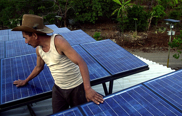 Raul Paz observes solar panels on a school in the rural community of San Ramon, Honduras, December 2001. (AP/Esteban Felix)