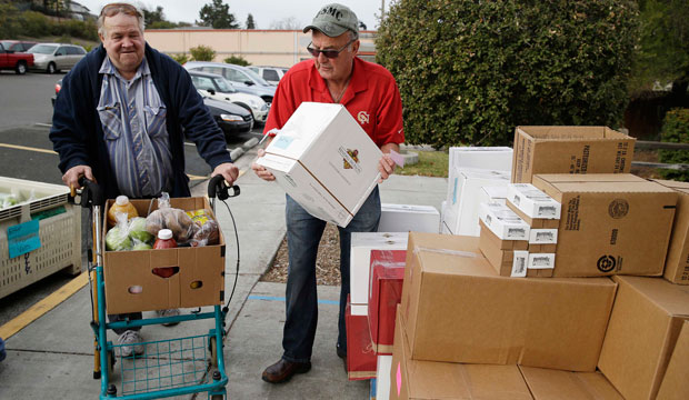 Steve Bosshard hands over a specially prepared box of food to Gordon Hanson at a food bank distribution in Petaluma, California, in January. (AP/Eric Risberg)
