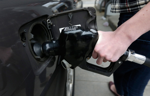 A customer fills her car with fuel at a gas station in Brookline, Massachusetts. (AP/Steven Senne)