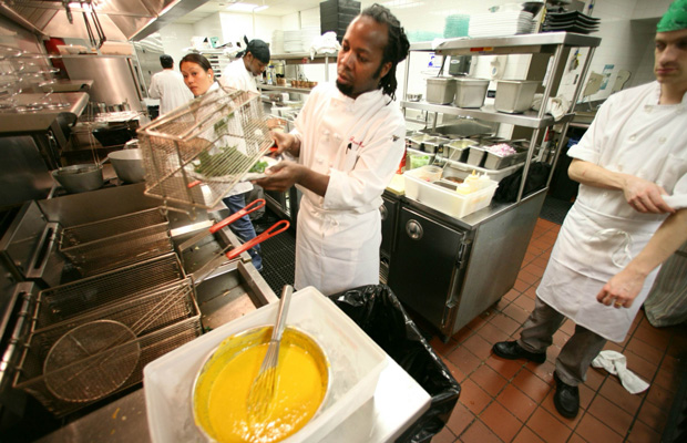 Haitian immigrant Jean Emy Pierre, head chef at Colors, a restaurant co-owned by a multinational immigrant staff, works with his kitchen staff as they prepare for dinner in New York. (AP/Bebeto Matthews)