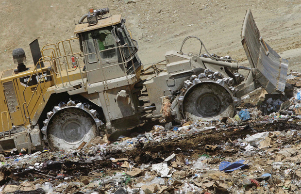 An earth mover buries waste at the Clinton Landfill near Clinton, Illinois. (AP/Seth Perlman)
