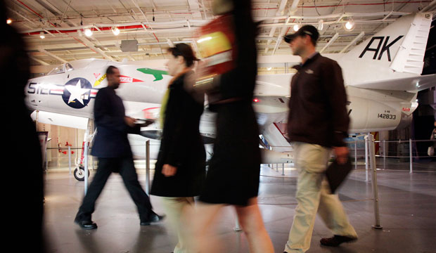 People pass a military jet while attending a job fair for veterans at the Intrepid Sea, Air, and Space Museum in New York City. (AP/Mark Lennihan)