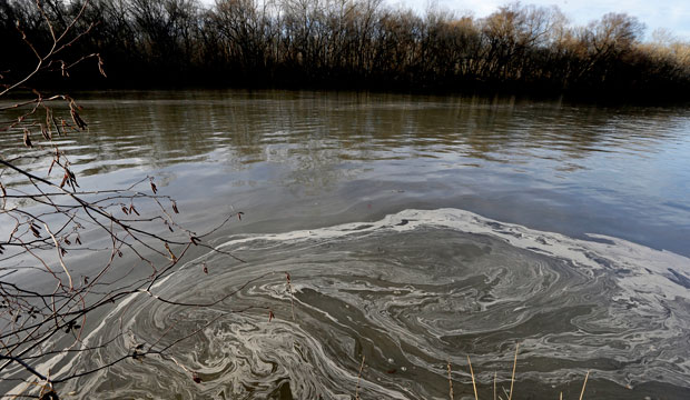 Signs of coal ash swirl in the Dan River after a spill at the Dan River Power Plant in Eden, North Carolina, on February 5, 2014. (AP/Gerry Broome)