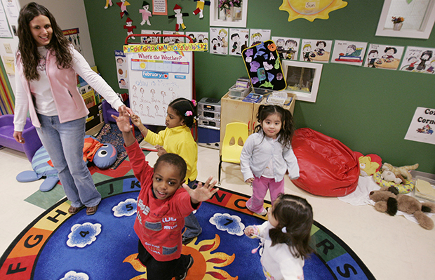 Three-year-old Nathan Austin, center, dances around his classroom with teacher Jennifer Grillo-Bates and classmates at the Egenolf Early Childhood Center in Elizabeth, New Jersey. (AP/Mike Derer)