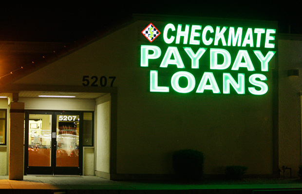 Neon signs illuminate a payday loan business in Phoenix, Arizona, in 2010. (AP/Ross D. Franklin)