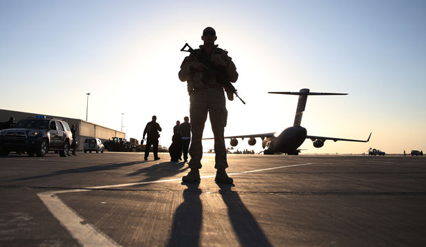 A soldier stands guard near a military aircraft in Kandahar, Afghanistan. (AP/Mark Wilson)