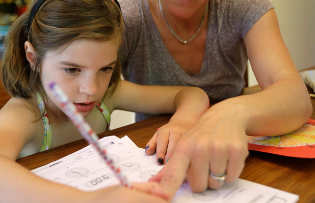 Stacey Jacobson-Francis works on math homework with her 6-year-old daughter at their home in Berkeley, California. (AP)