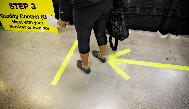 An arrow on the floor points the way for homeowners attempting to lower their monthly mortgage payment at a mortgage relief event in Atlanta, September 2014. (AP/David Goldman)
