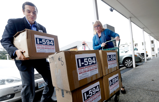 Supporters deliver boxes of petitions for Initiative 594 to the Secretary of State's office Wednesday, October 9, 2013, in Olympia, Washington. (AP/Elaine Thompson)