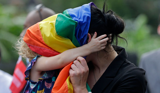 Ariel David and her daughter, Nelly David, play with a pride flag during a rally in New Orleans on September 3, 2014. (AP/Gerald Herbert)