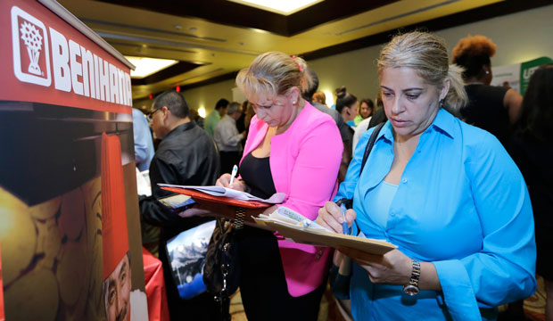 Job seekers Madelin Garcia, right, and Noharis Nunez fill out a job applications at a job fair in Miami Lakes, Florida. (AP/Alan Diaz)