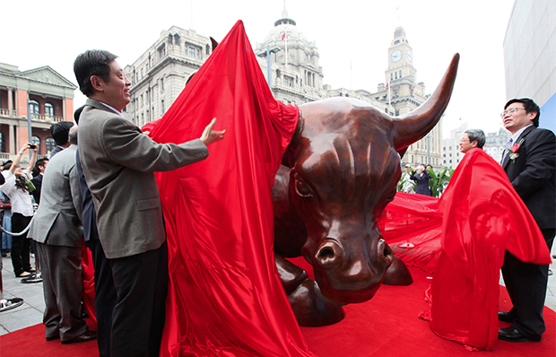 Local officials unveil Italian-American artist Arturo Di Modica's new Charging Bull statue, which is a similar version of his Wall Street Bull, Saturday, May 15, 2010, on the Bund in Shanghai, China. (AP/Eugene Hoshiko)