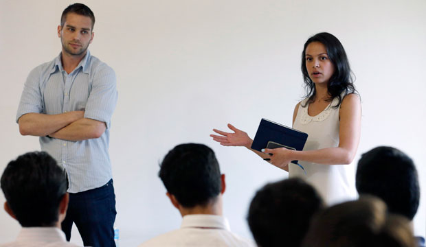 Elisabeth Deogracias and Mike Tarullo of Venture For America talk during a presentation in Miami. Venture For America pairs college seniors and recent graduates with startup companies for a two-year fellowship. (AP/Wilfredo Lee)