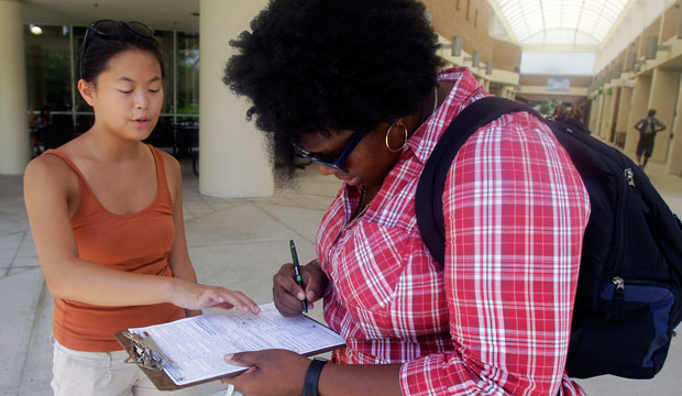 Aubrey Marks, left, helps a University of Central Florida student to register to vote in Orlando on July 31, 2012. (AP/John Raoux)
