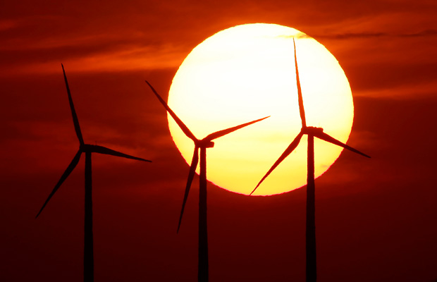 Wind turbines are silhouetted by the setting sun near Beaumont, Kansas. (AP/Charlie Riedel)