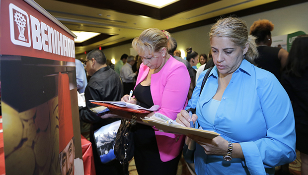 Job seekers Madelin Garcia, right, and Noharis Nunez fill out job applications at a job fair in Miami Lakes, Florida, October 22, 2014. (AP/Alan Diaz)