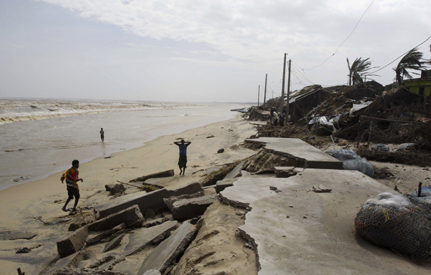 Residents of the coastal Indian village of Podampeta in Odisha state survey the damage caused by Cyclone Phailin after it made landfall from the Bay of Bengal, October 12, 2013. (AP)