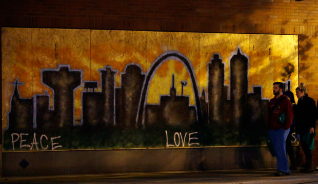 People walk by a mural on a boarded-up business on November 25, 2014, in south St. Louis, Missouri. (AP/Jeff Roberson)