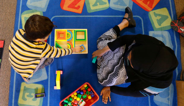 Declan Hart, 4, and teacher-in-training Deassi Usman play with shape blocks during a prekindergarten class at the Community Day Center for Children in Seattle. (AP/Ted S. Warren)