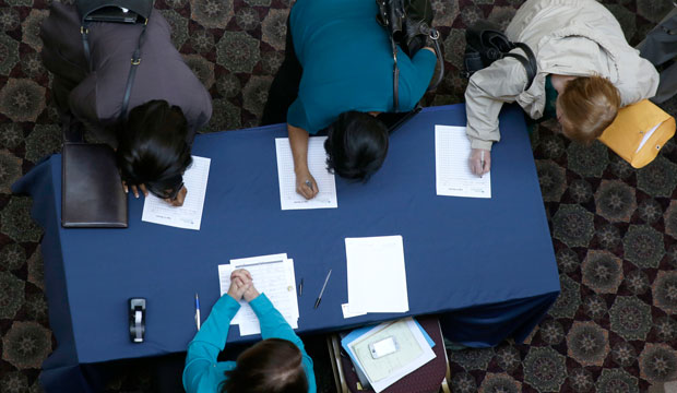 Job seekers sign in before meeting prospective employers during a career fair at a hotel in Dallas, January 2014. (AP/LM Otero)