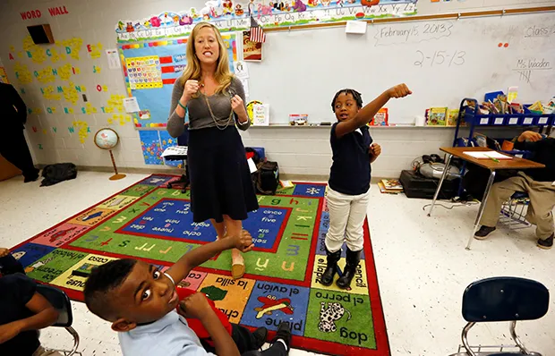 Myrtle Hall IV Elementary School teacher Gabrielle Wooden, left, and Camilyn Anderson, 7, lead their first-grade class in a live-action Spanish class in Clarksdale, Mississippi, February 15, 2013. (AP/Rogelio V. Solis)