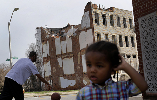 A boy whose family asked that he not be identified plays across the street from a partially collapsed row house in Baltimore, Maryland, April 8, 2013. (AP/Patrick Semansky)