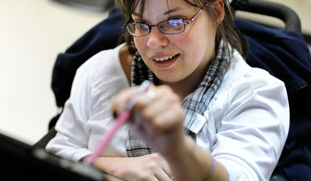 Jennifer Lortie, who has limited arm and leg use due to cerebral palsy, works on an iPad in her Willimantic, Connecticut, office. (AP/Jessica Hill)