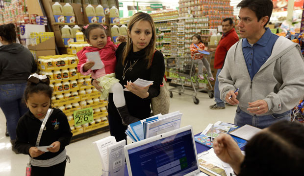 Grocery shoppers stop at a Blue Cross Blue Shield kiosk promoting the Affordable Care Act at Compare Foods in Winston-Salem, North Carolina. (AP/Gerry Broome)