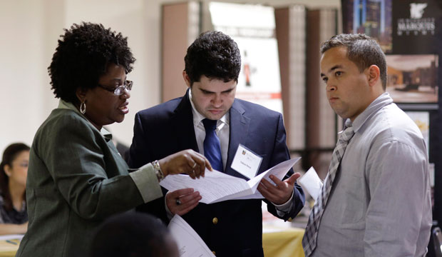 Instructor Lavinda Young, left, helps Fabian Perez, center, and Lazaro Chaviano, right, with their resumes during a job fair at the Hospitality Institute, in Miami on January 23. (AP/Lynne Sladky)
